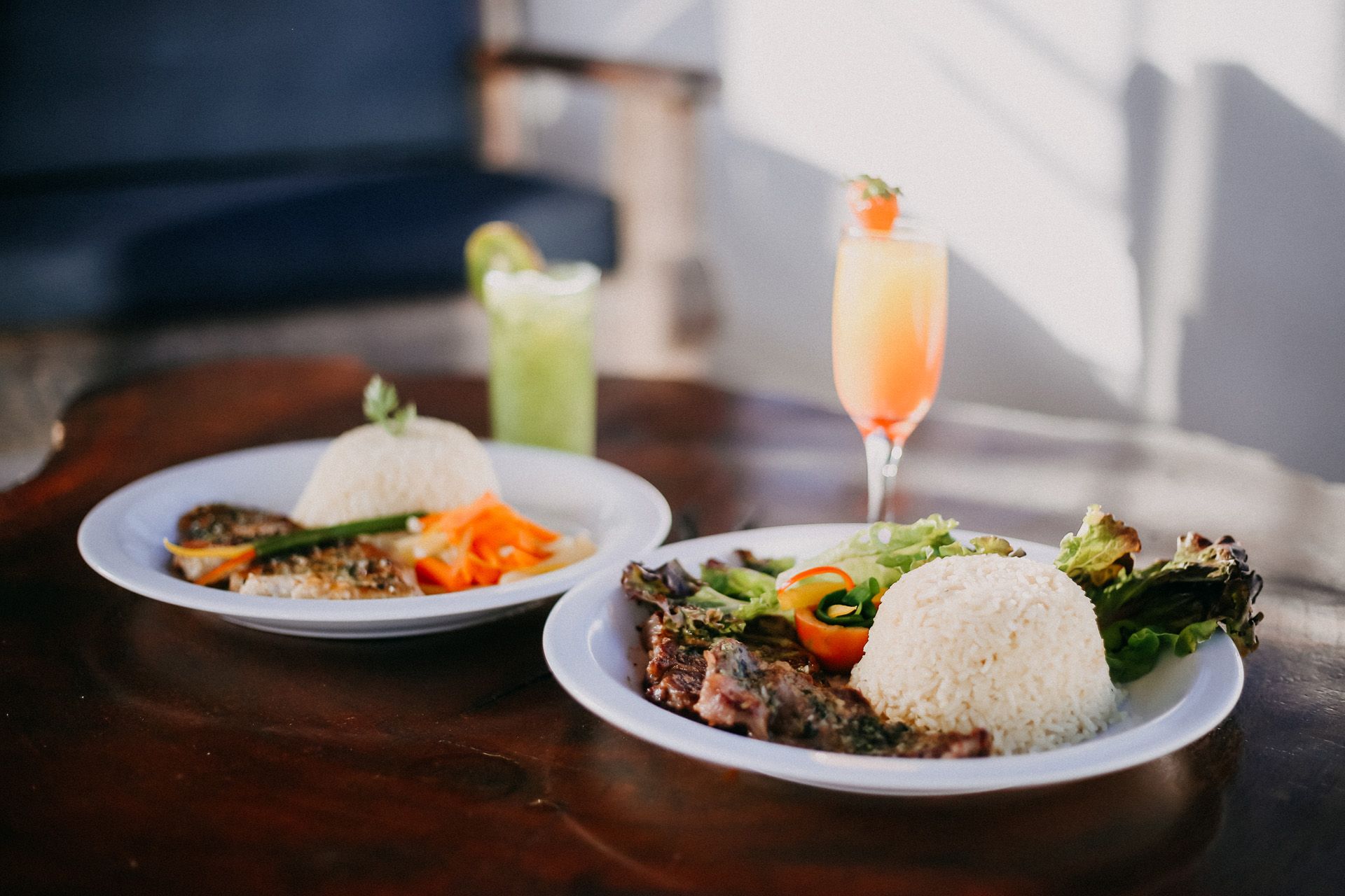Buffet de café da manhã com diversos itens alimentares: pães, bolos, frutas e pratos quentes, em um refeitório.