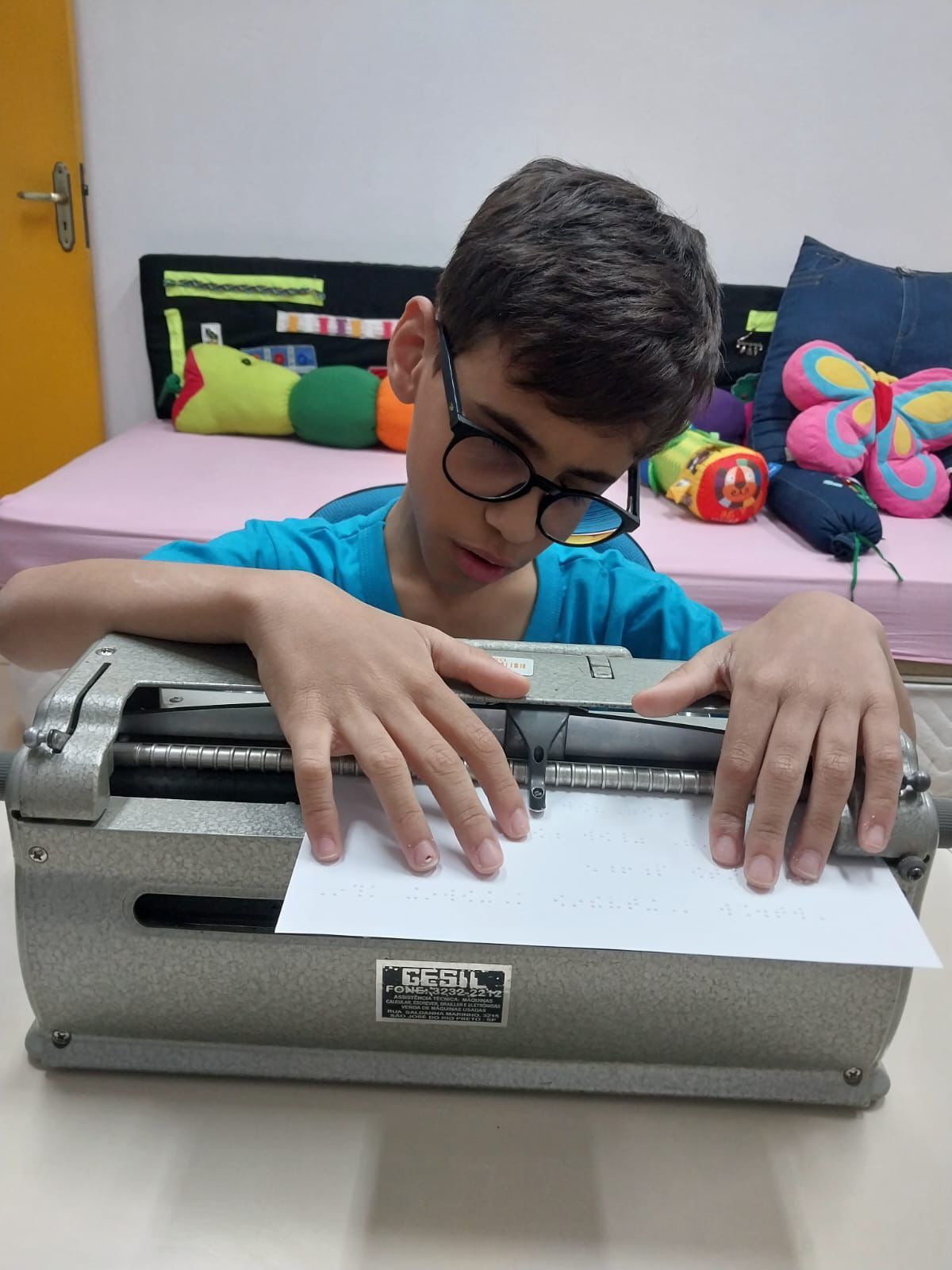 Mulher adulta escrevendo em uma máquina de braille.