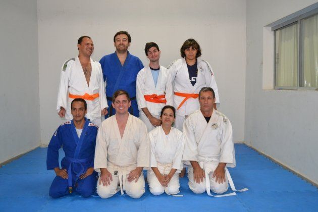 Um grupo de pessoas em uniformes de caratê estão posando para uma foto