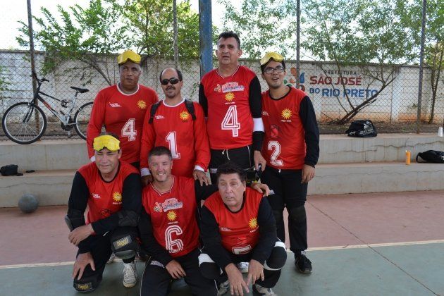 Um grupo de homens vestindo camisas vermelhas com o número 4 nelas