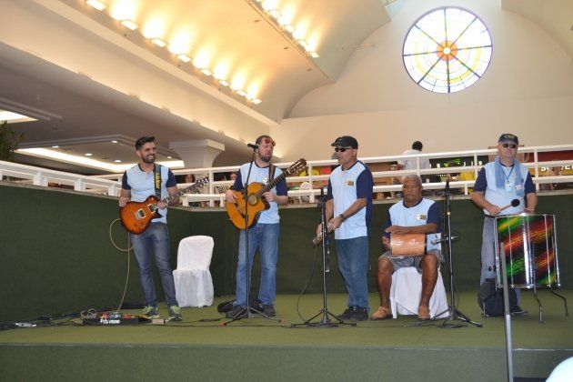 Um grupo de homens tocando guitarra e bateria em um palco