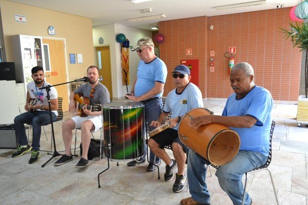 Um grupo de homens está tocando bateria e guitarra em uma sala.