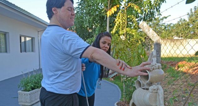 Um homem e uma mulher estão regando uma fonte em um jardim.