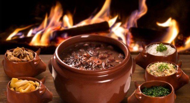 Uma panela de comida está sobre uma mesa em frente ao fogo.