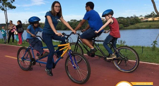 Um grupo de pessoas anda de bicicleta dupla em uma estrada.