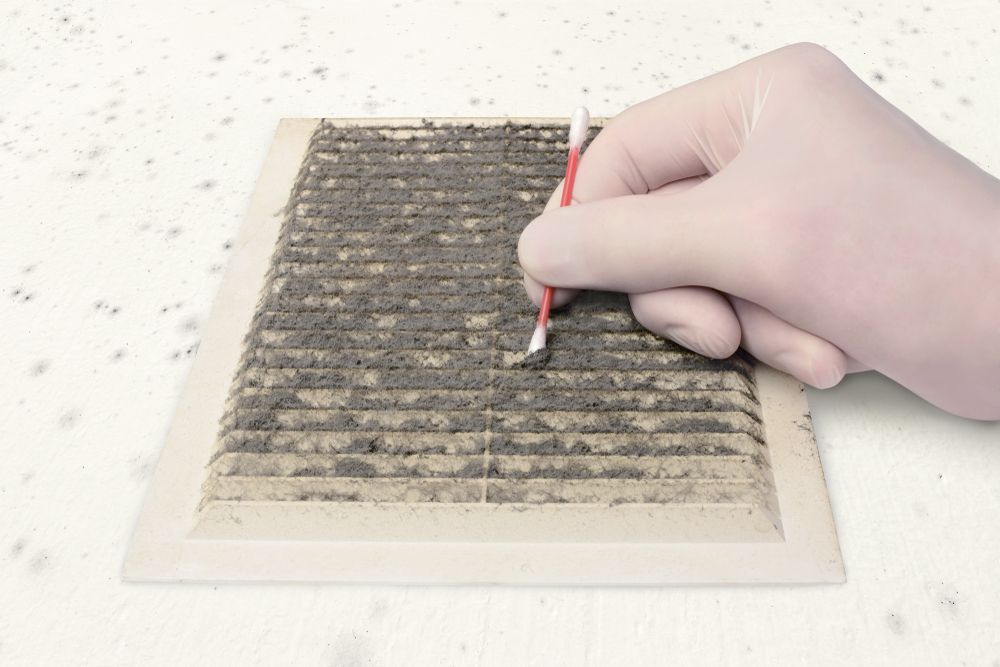 A person is cleaning a vent with a cotton swab.