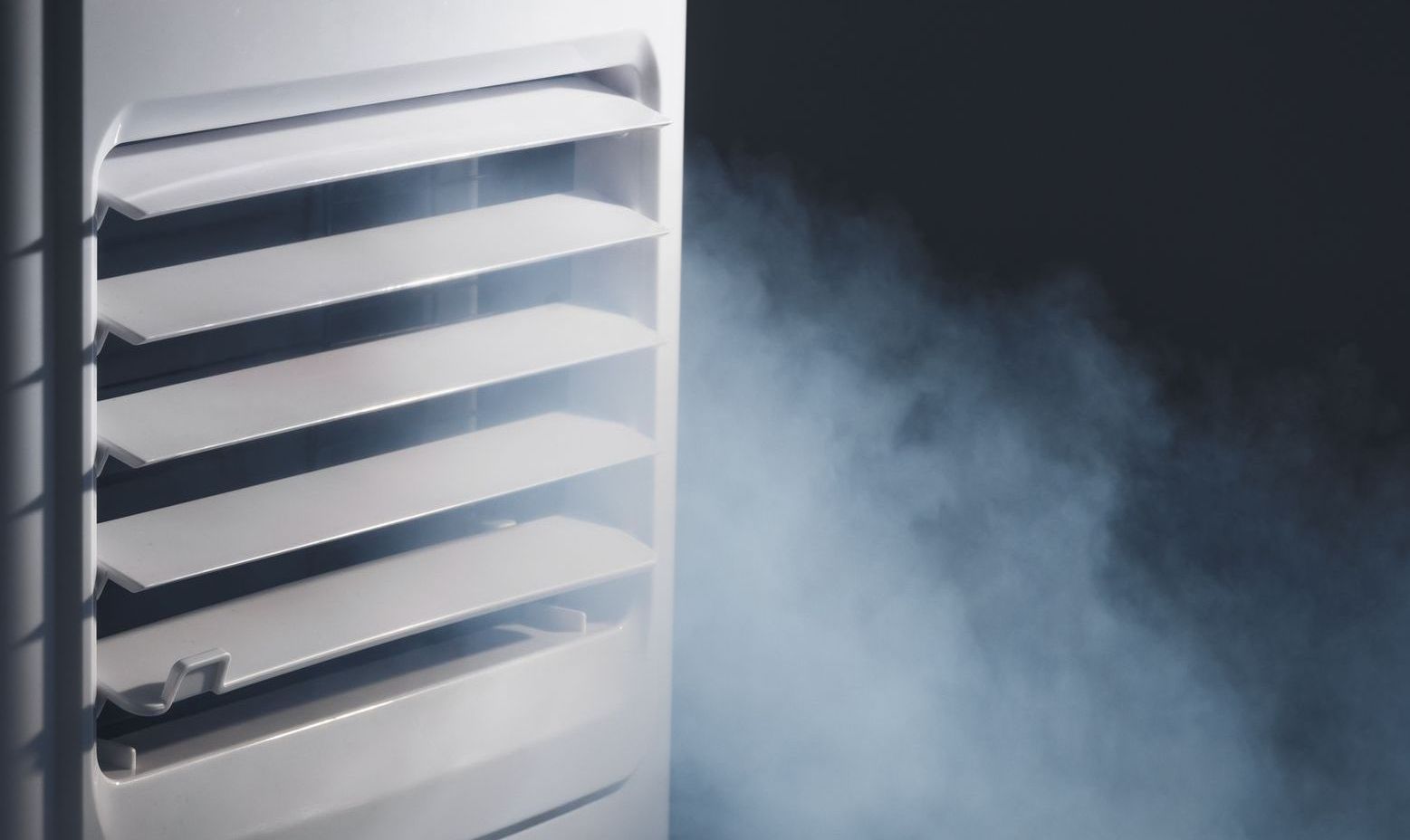 A white air conditioner with smoke coming out of it.