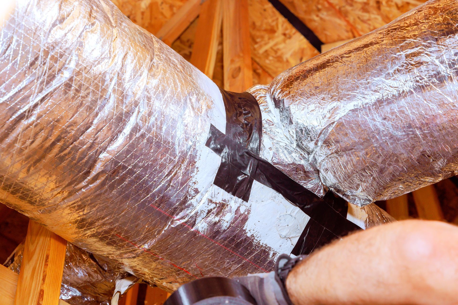 A person is cutting a duct with a pair of scissors.