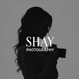 Silhouette of a photographer holding a camera with “SHAY PHOTOGRAPHY” text on a gray background