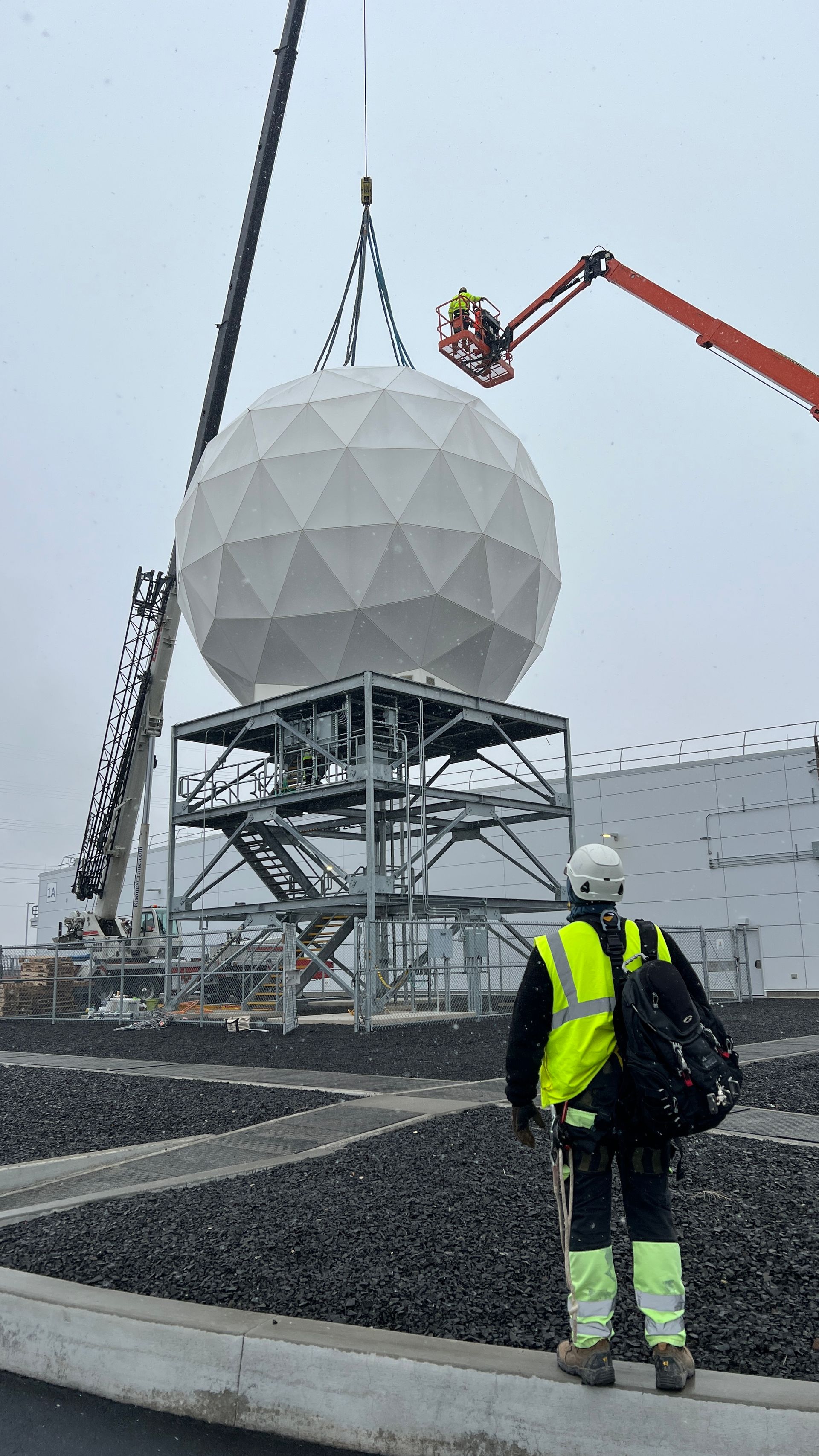 Satellite antenna protective dome being craned into place over an antenna