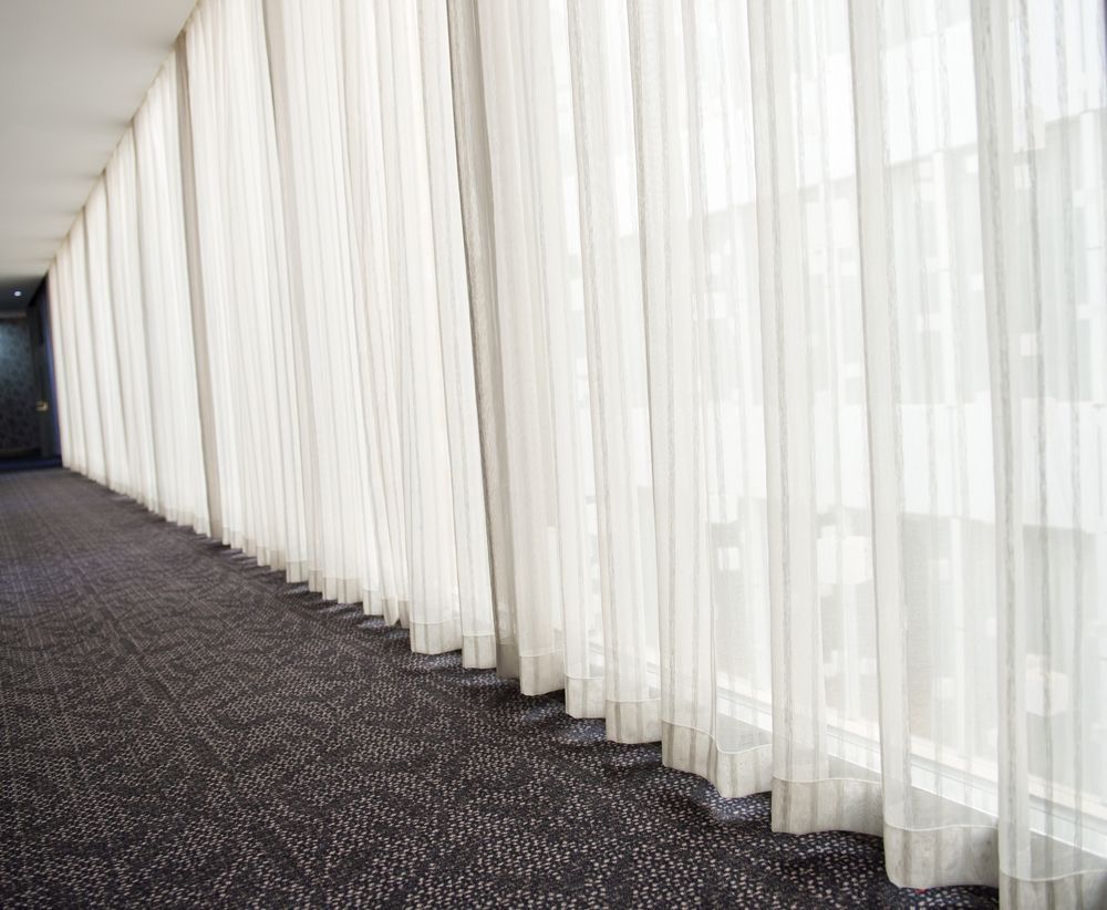 White Sheer Curtains Cover a Long Window, Beside a Carpeted Hallway — Atherton Decor Centre In Ravenshoe, QLD