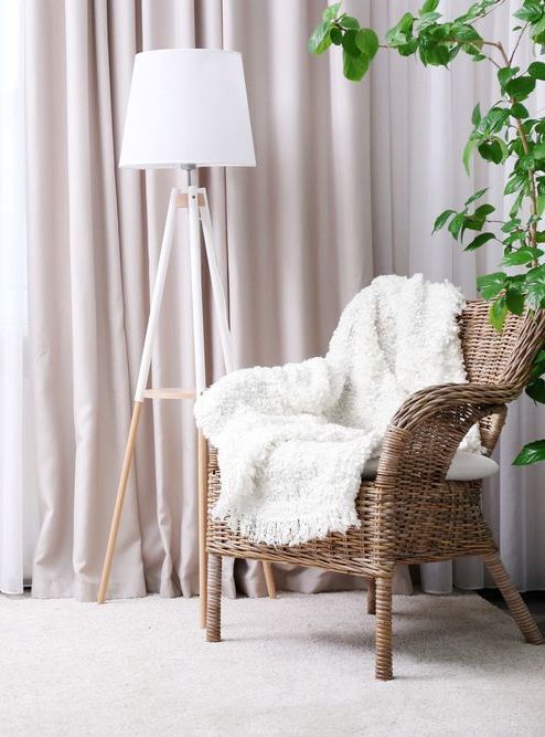 A Wicker Chair With a White Blanket and a Lamp in a Living Room — Atherton Decor Centre In Atherton, QLD