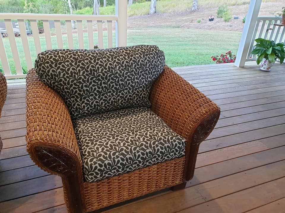 A Wicker Chair is Sitting on a Wooden Deck — Atherton Decor Centre In Atherton, QLD