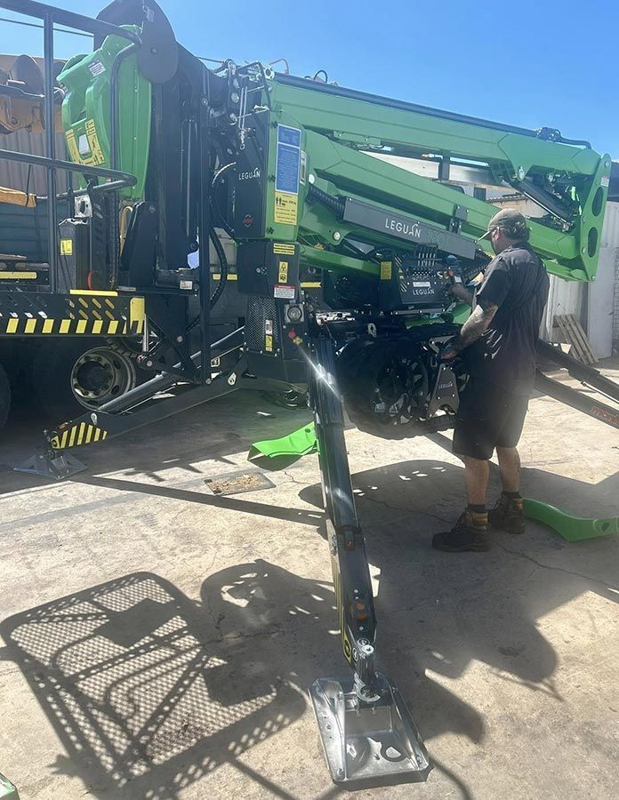 A Man is Standing Next to a Green Crane in a Parking Lot — OG Diesel NQ in Garbutt, QLD