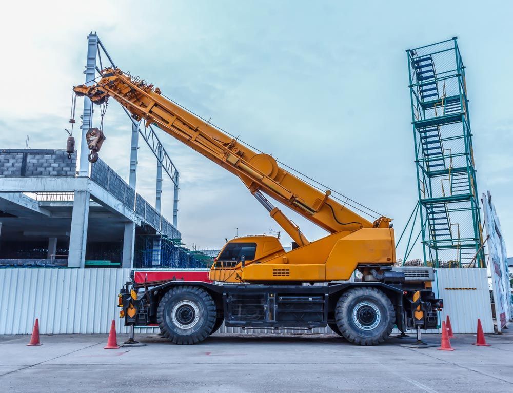 A Large Yellow Crane is Parked in Front of a Building Under Construction — OG Diesel NQ in Garbutt, QLD