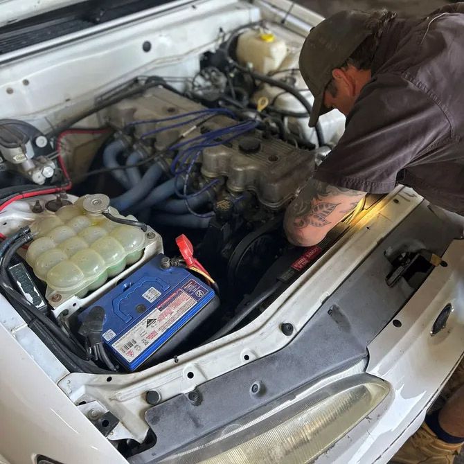 A Man is Working on the Engine of a White Car — OG Diesel NQ in Garbutt, QLD