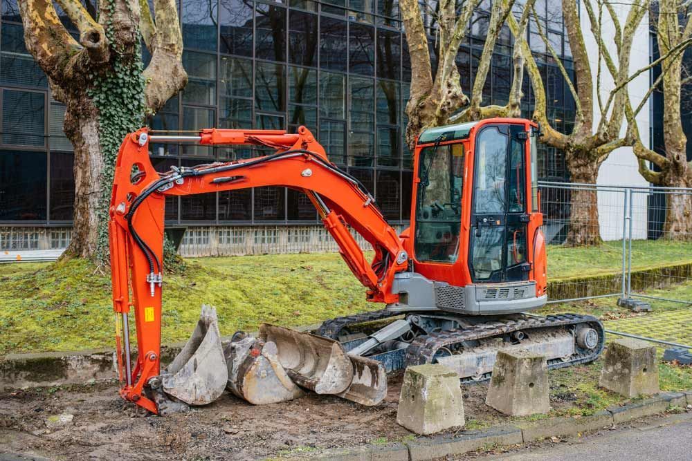 An Orange Excavator is Parked on the Side of the Road in Front of a Building — OG Diesel NQ in Garbutt, QLD