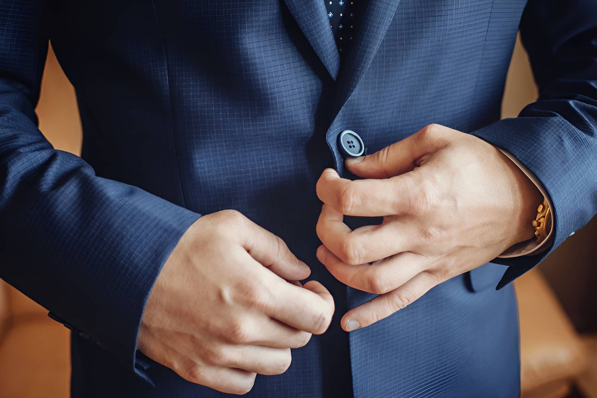 A Man in a Suit and Tie is Adjusting His Jacket Buttons — Bonanno's Menswear in Heathcote, Nsw