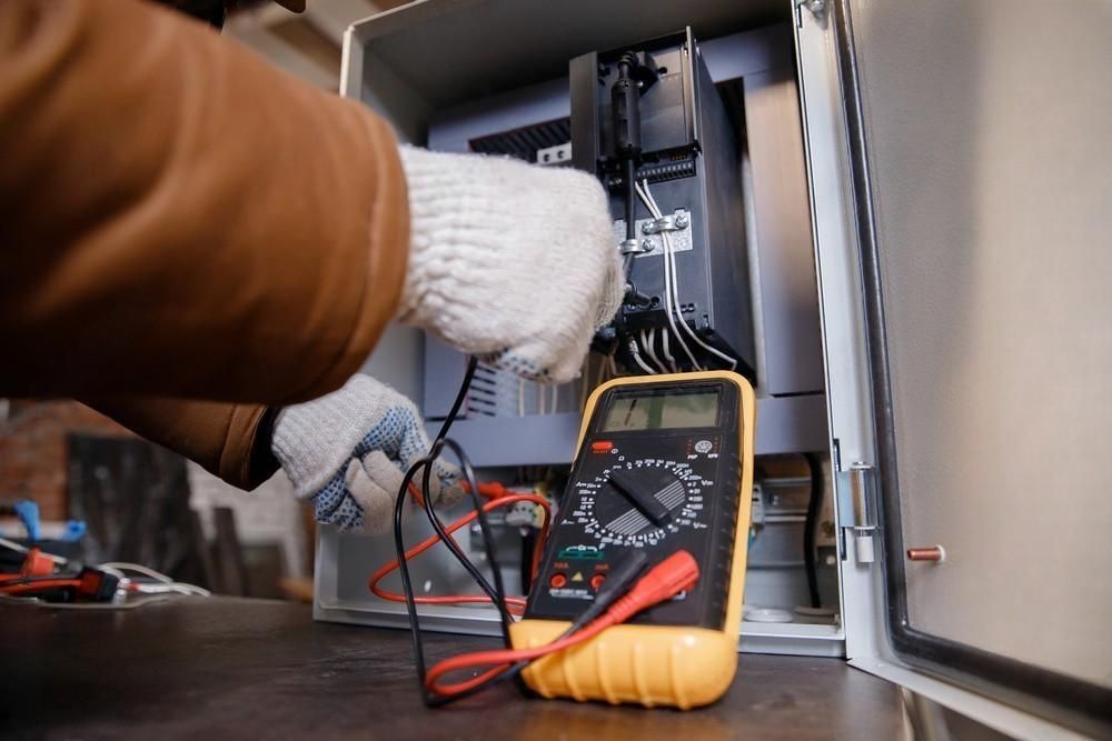 A person is using a multimeter to test a circuit board.