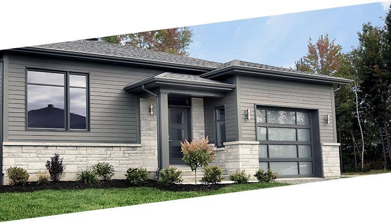 Une petite maison avec un garage et beaucoup de fenêtres.