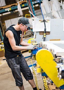 Un homme travaille sur une machine dans une usine.
