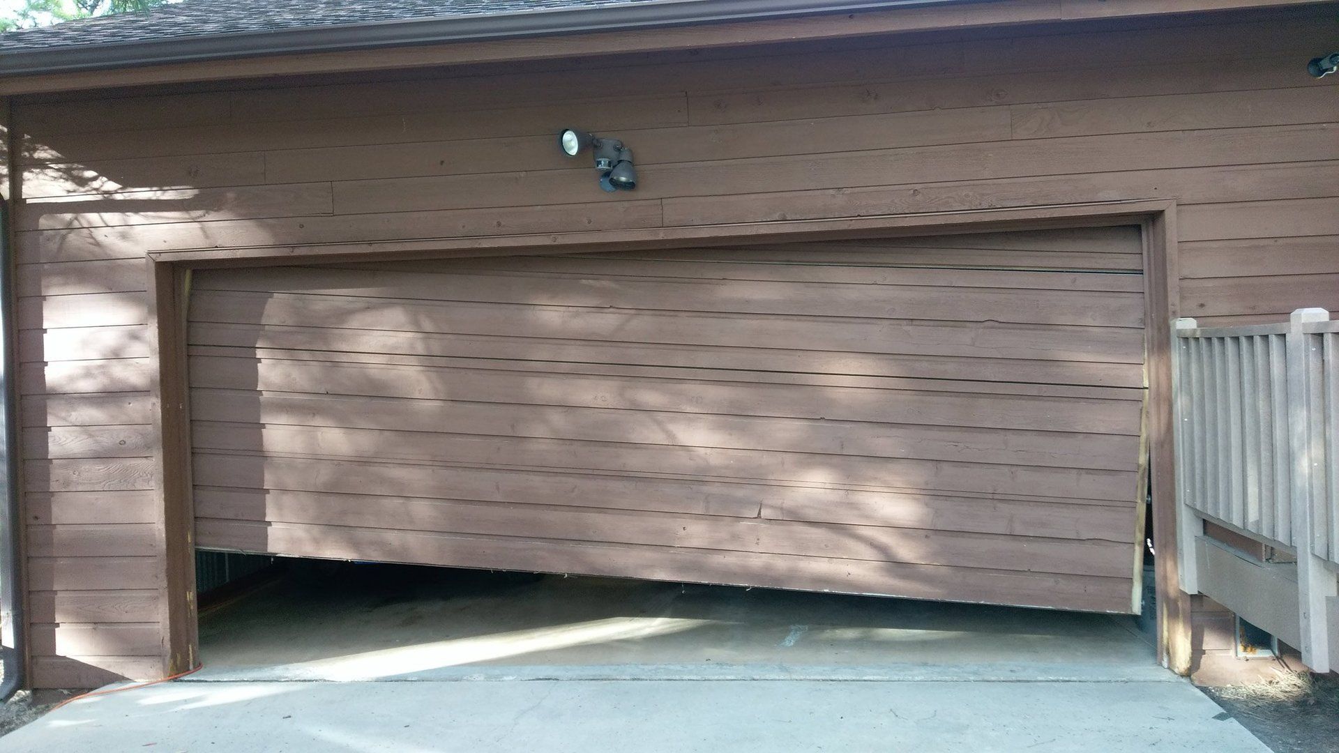 A brown garage door is off its rails