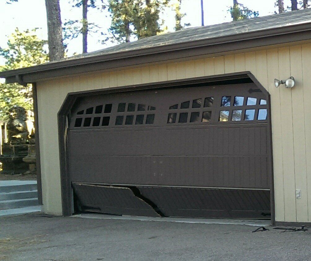 A brown garage door with a broken section of it
