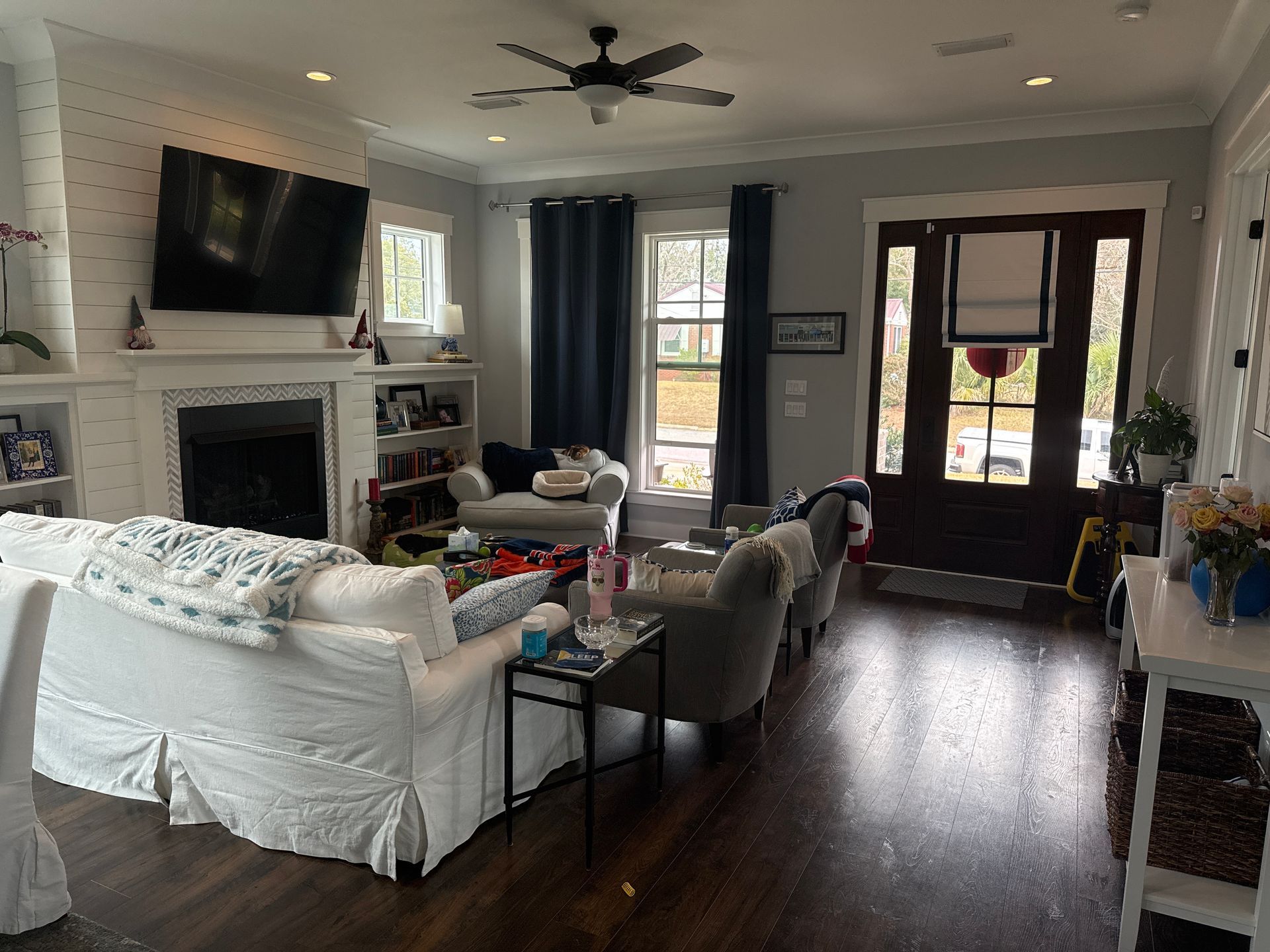 A living room with a couch , chairs , a fireplace and a flat screen tv.