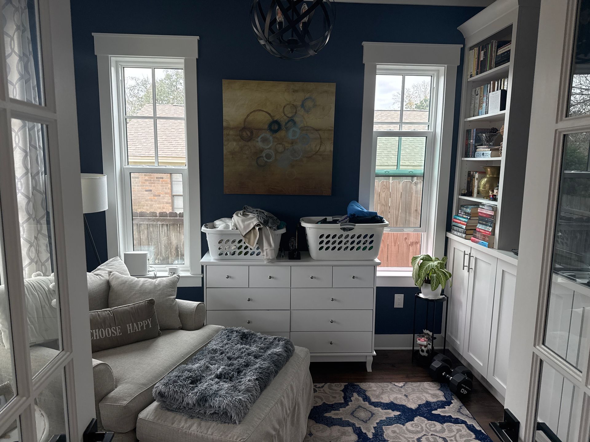 A living room with blue walls and white furniture