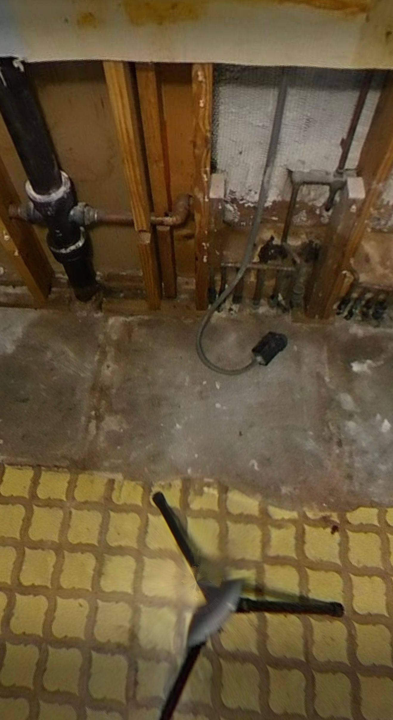 A microphone is sitting on a tripod in a basement.