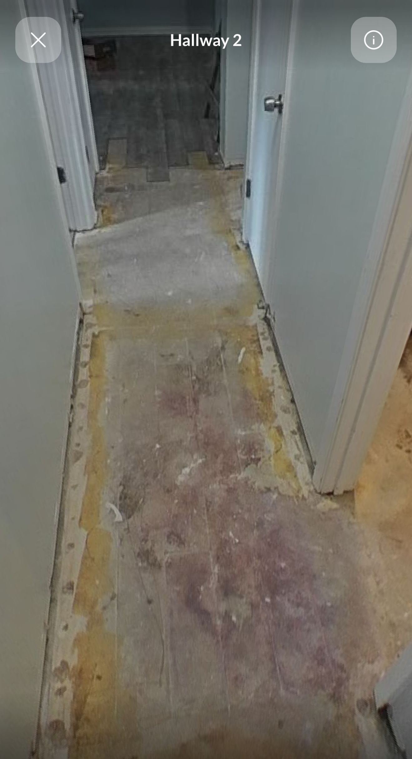 A hallway with a dirty floor and a door.