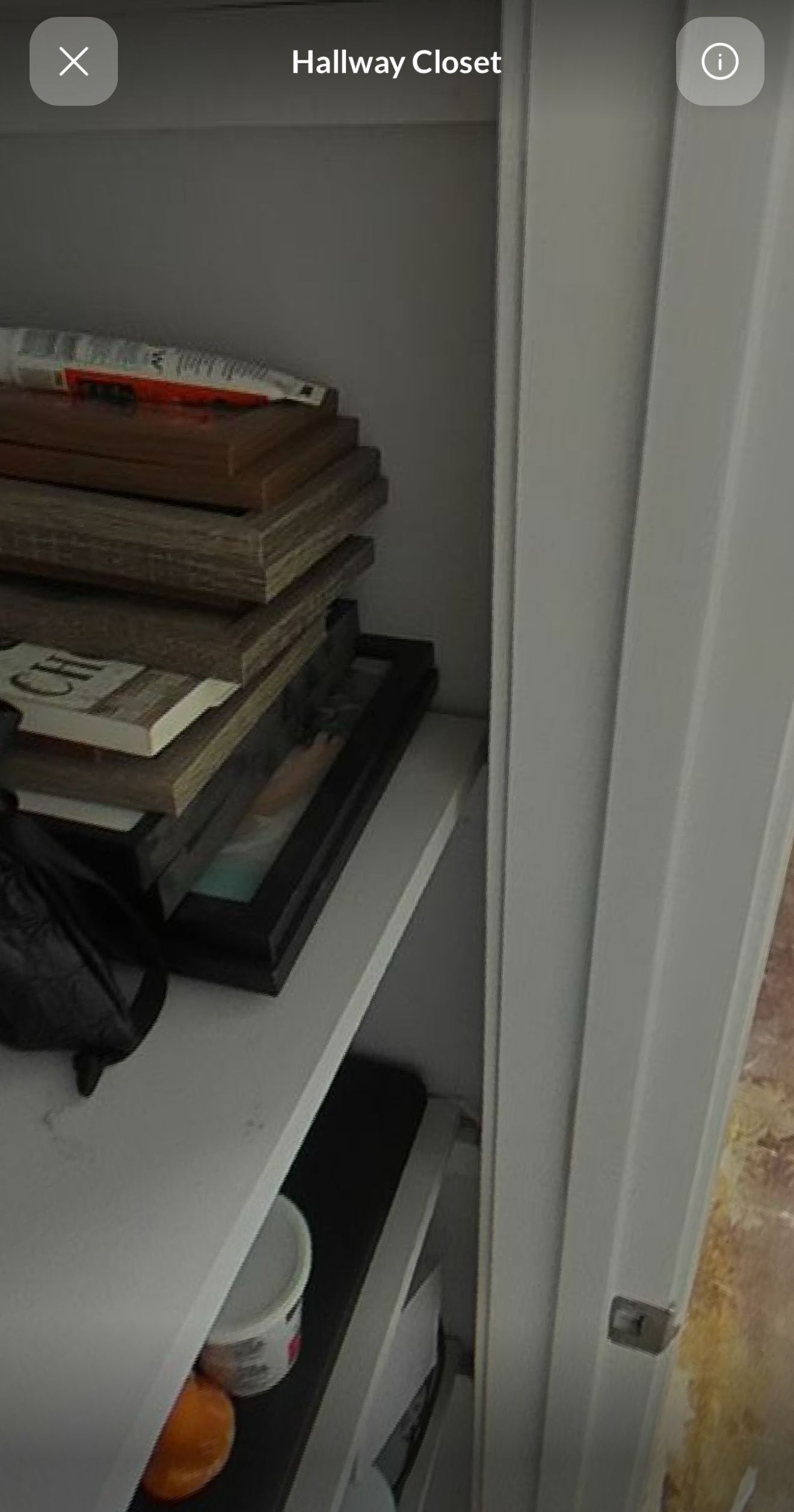 A stack of books sitting on top of a shelf in a closet.