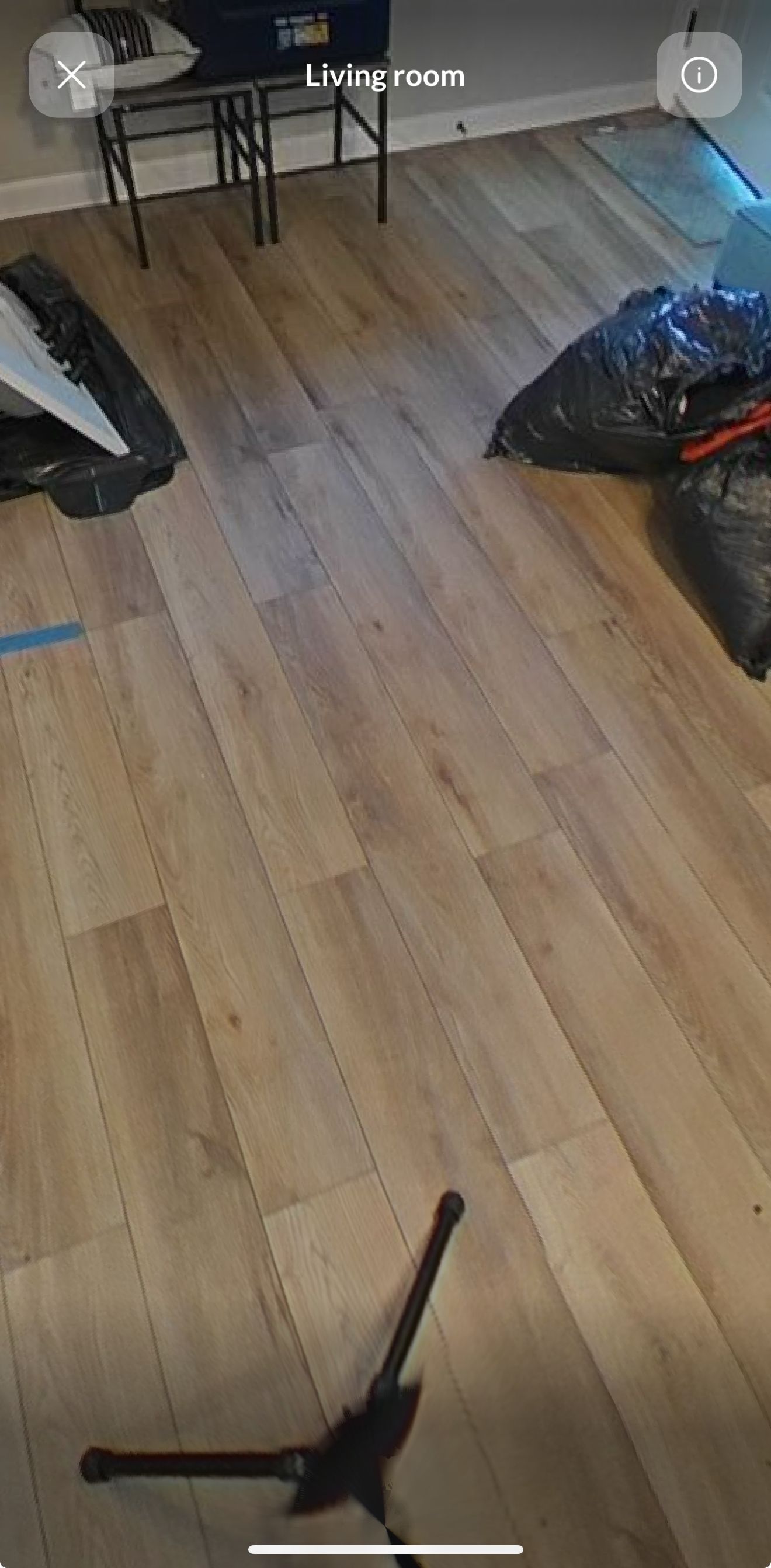 A microphone is sitting on a wooden floor in a room.