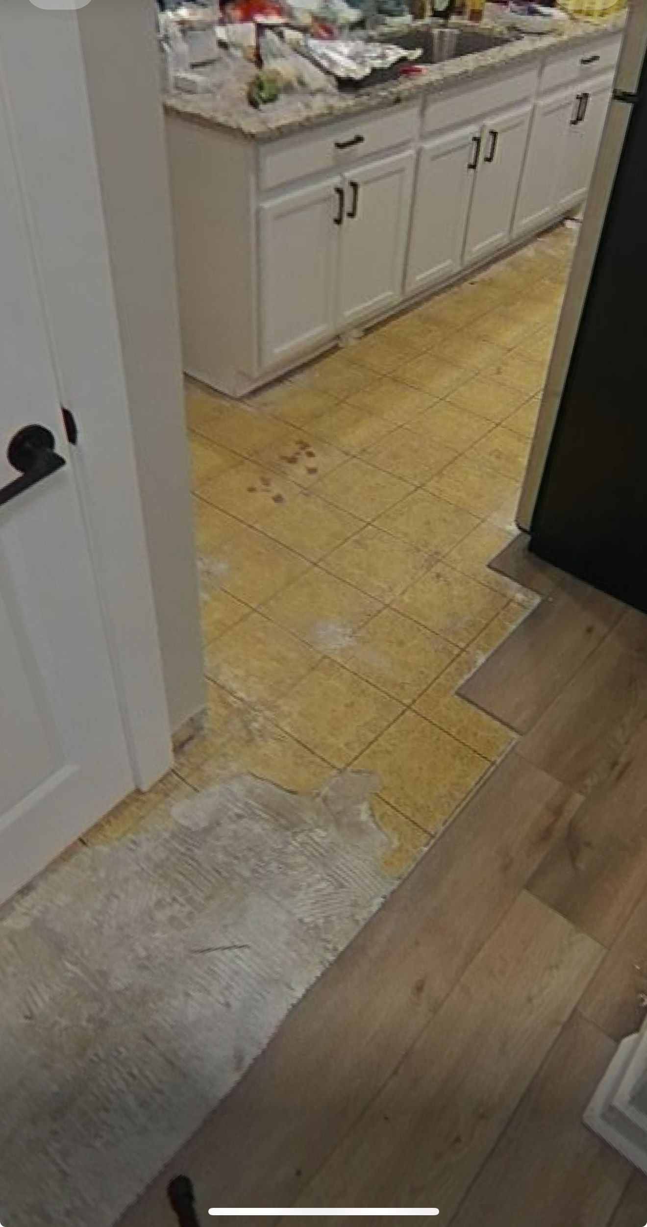 A kitchen with a wooden floor and white cabinets.
