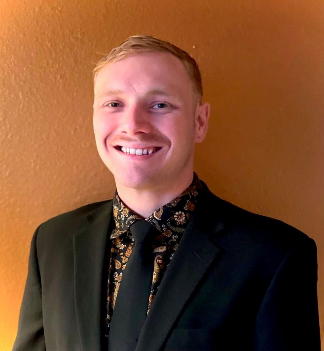 A man in a suit and tie is smiling for the camera.