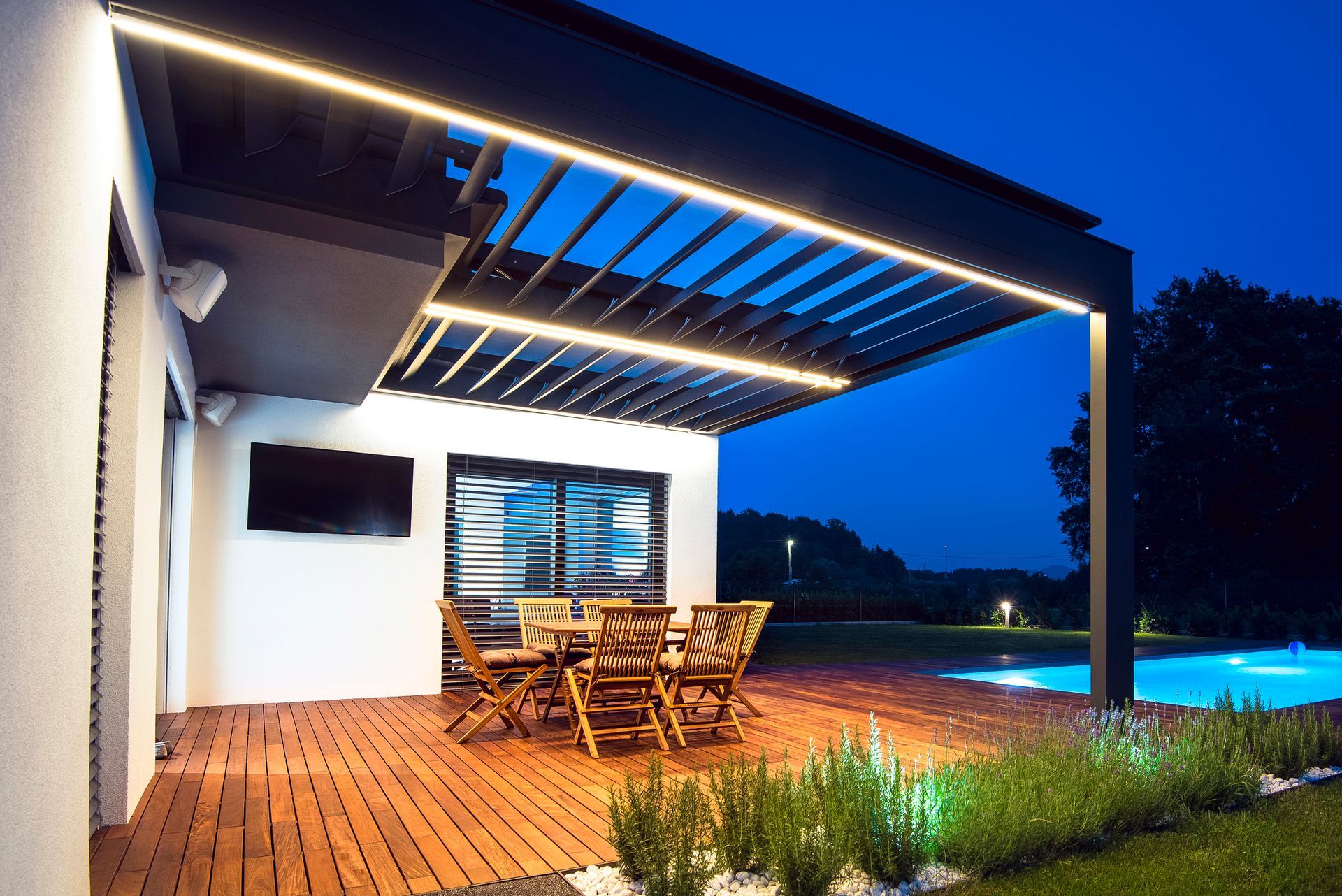 A wooden deck with a table and chairs under a pergola.