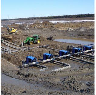 Un tracteur John Deere traverse un champ boueux