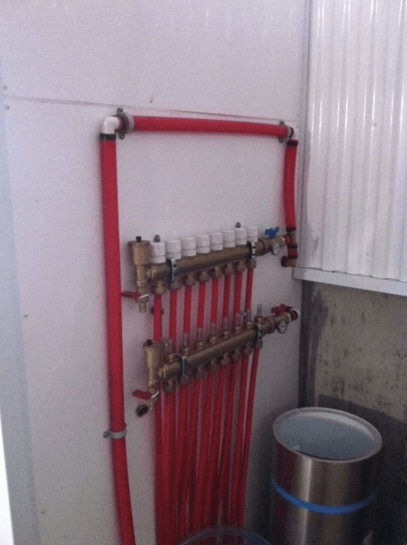 Un tas de tuyaux rouges sont accrochés à un mur