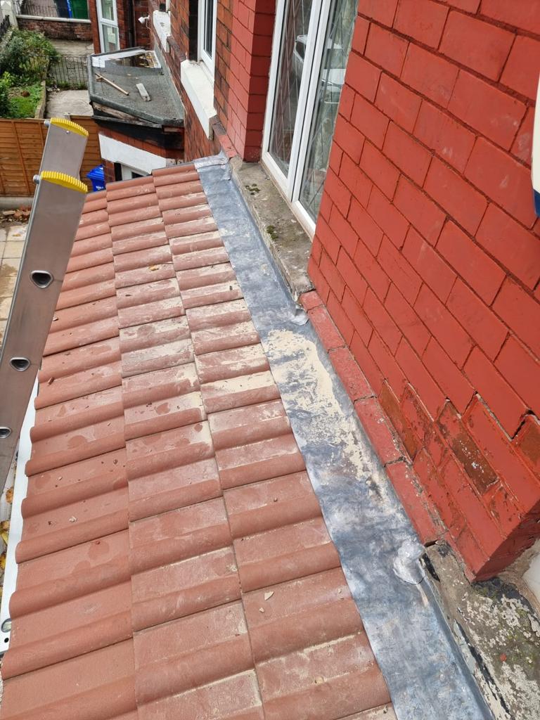 A picture of a new porch extension roof in red concrete profile tile by Roofers Manchester