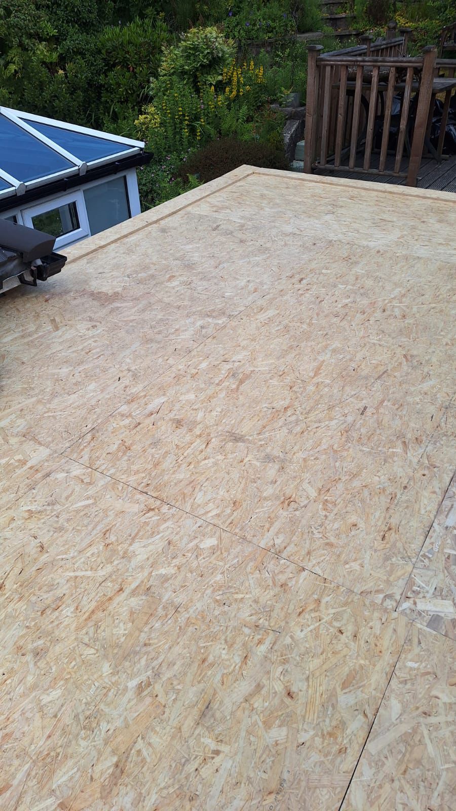 A wooden roof with a wooden deck in the background.