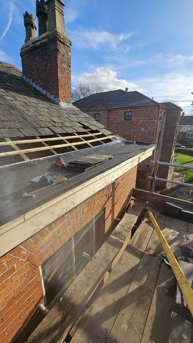 A picture of the Manchester roofing repairs team carrying out a slate roof repair on the Banana Moon Day Nursery