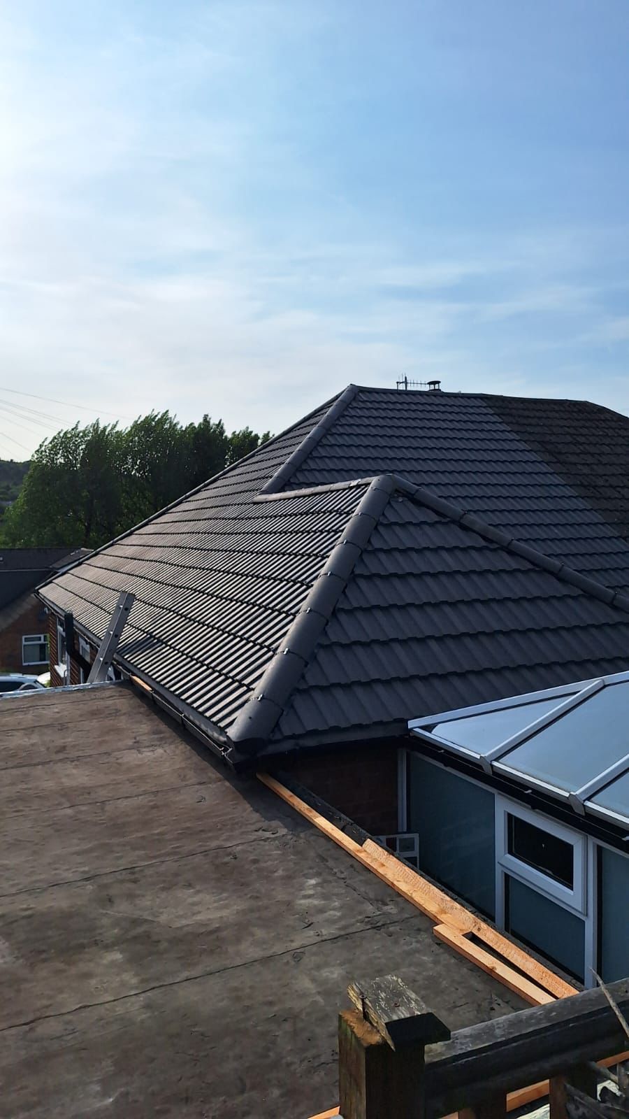 A roof of a house with a blue sky in the background.