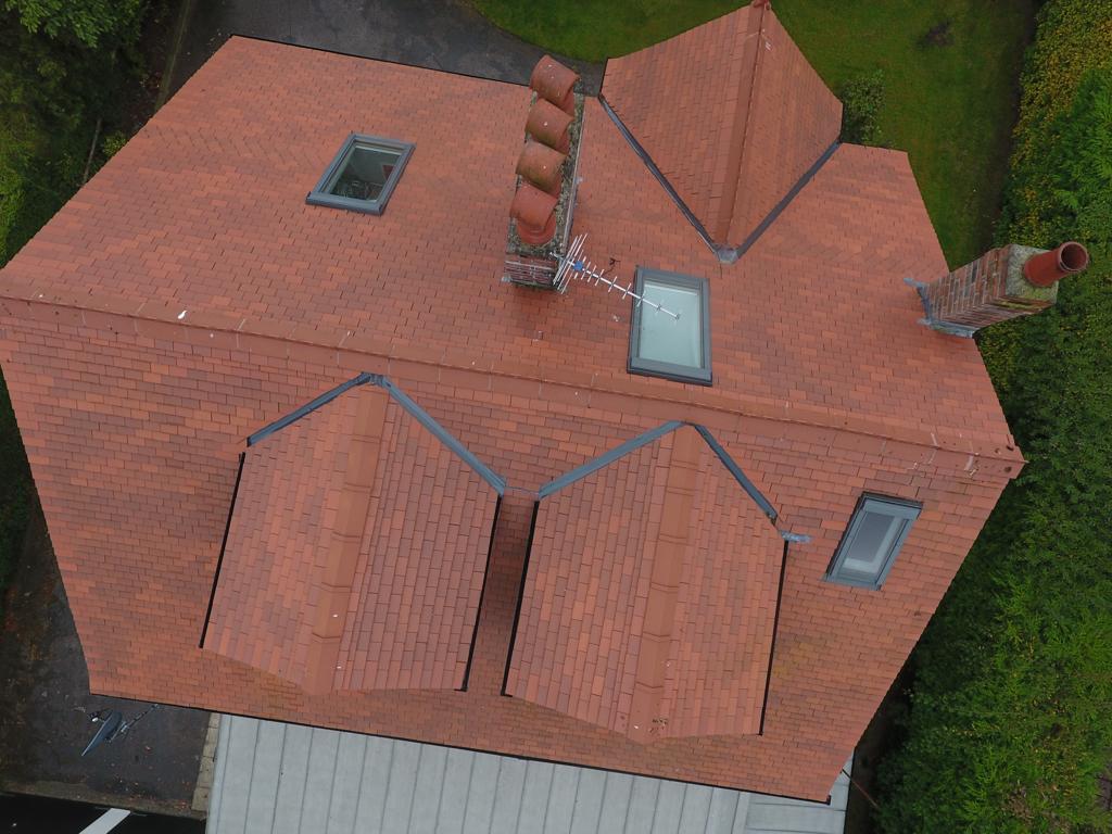 Picture of a new red clay tile roof replaced by roofers Manchester