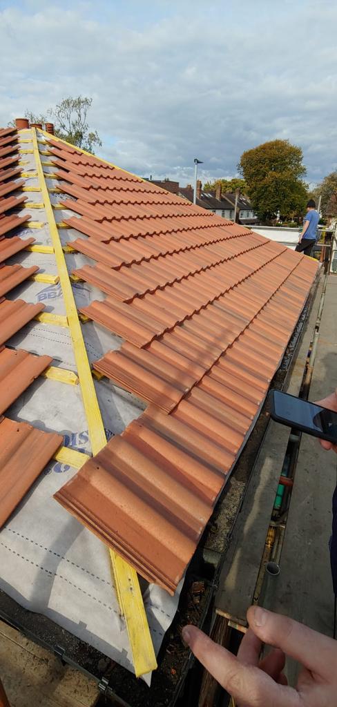 A picture of a hipped roof during replacement by Roofers Manchester