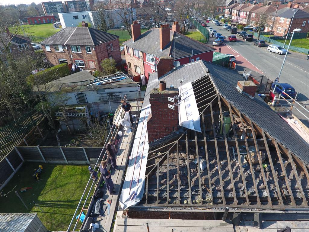 Picture of a semi detached hipped roof that has been stripped ready for replacement by Roofers Manchester