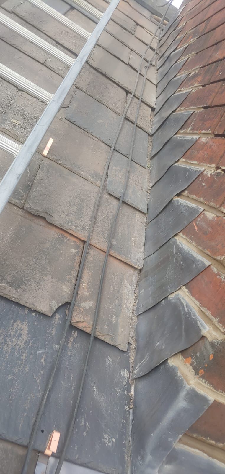 A close up of a roof with a chimney and flahsing on it.