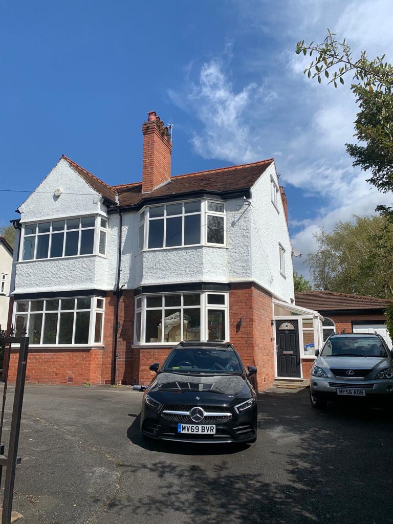 A picture of the front elevation of a large detached property that has been reroofed by Roofers Manchester