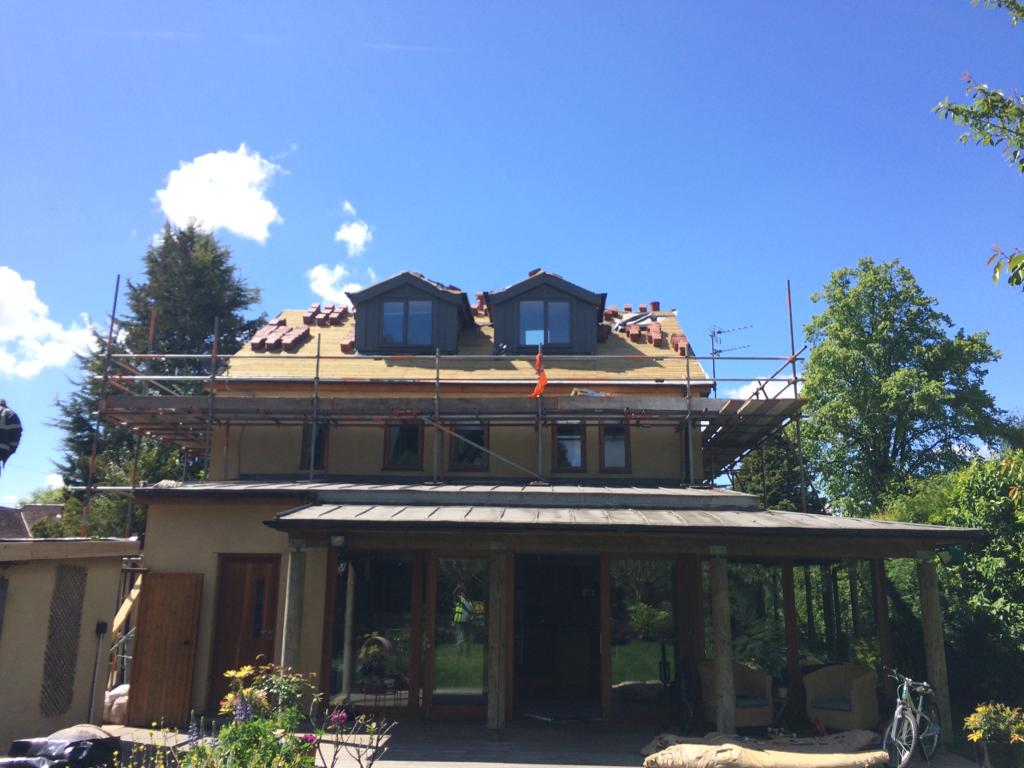 A picture of a detached property undergoing a roof replacement by roofers Manchester
