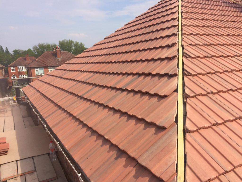 Picture of a new hipped roof carried out by Roofers Manchester in red concrete profile tile.