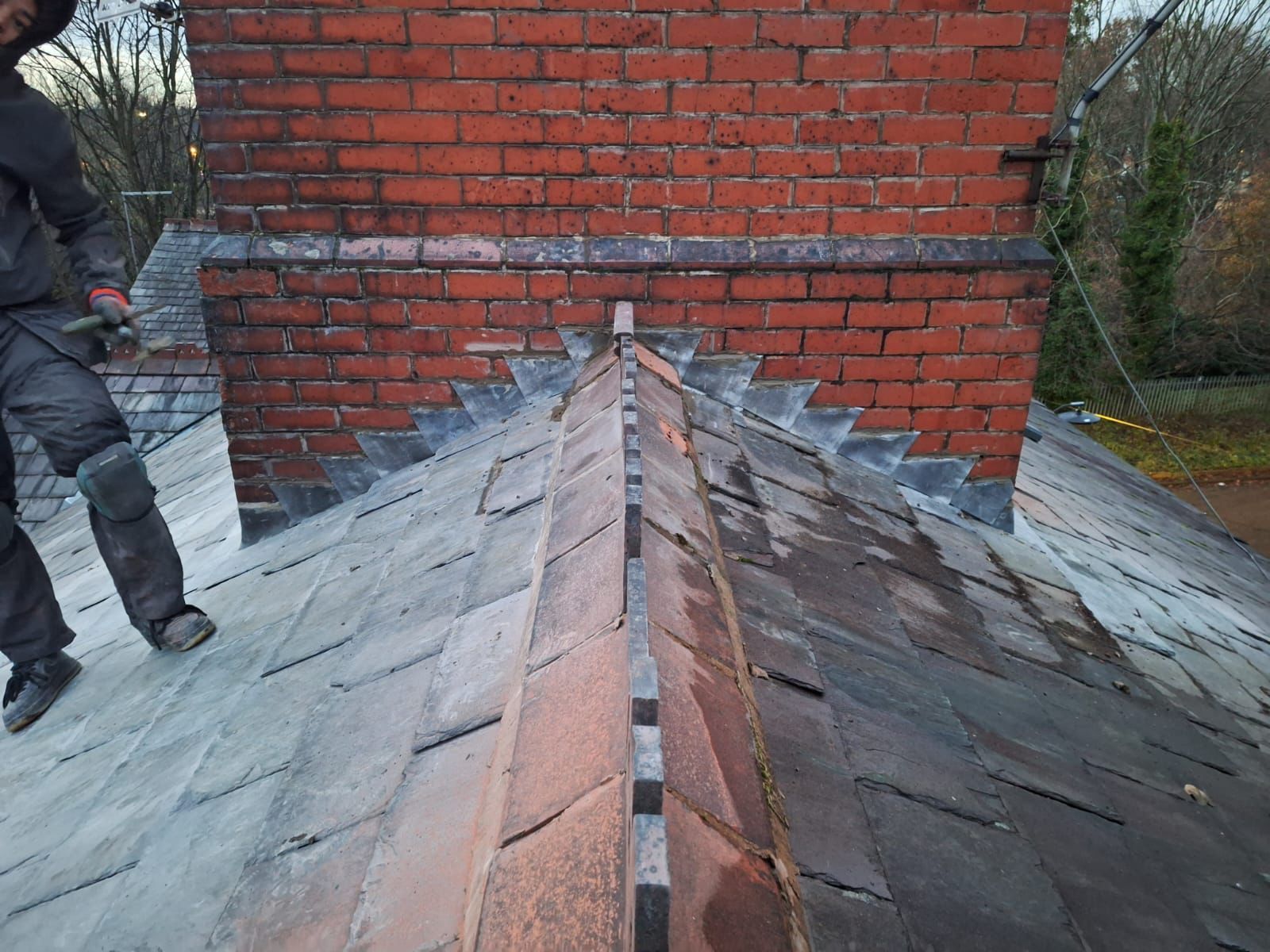 A picture of a ridge tile replacement and chimney flashing repair carried out by the Manchester Roofing team